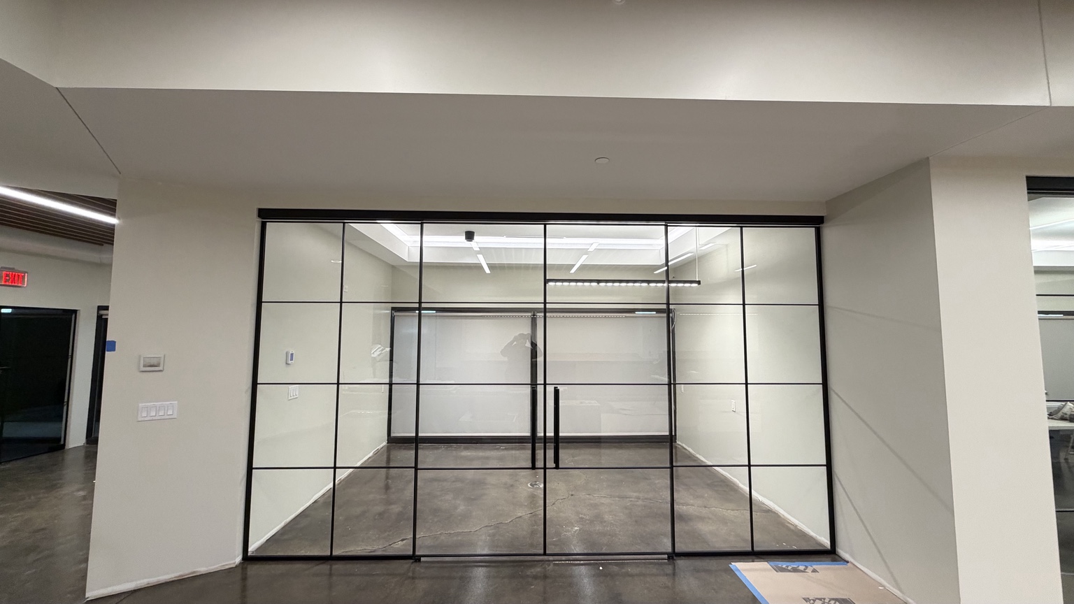 Full-width commercial glass wall with centered double doors