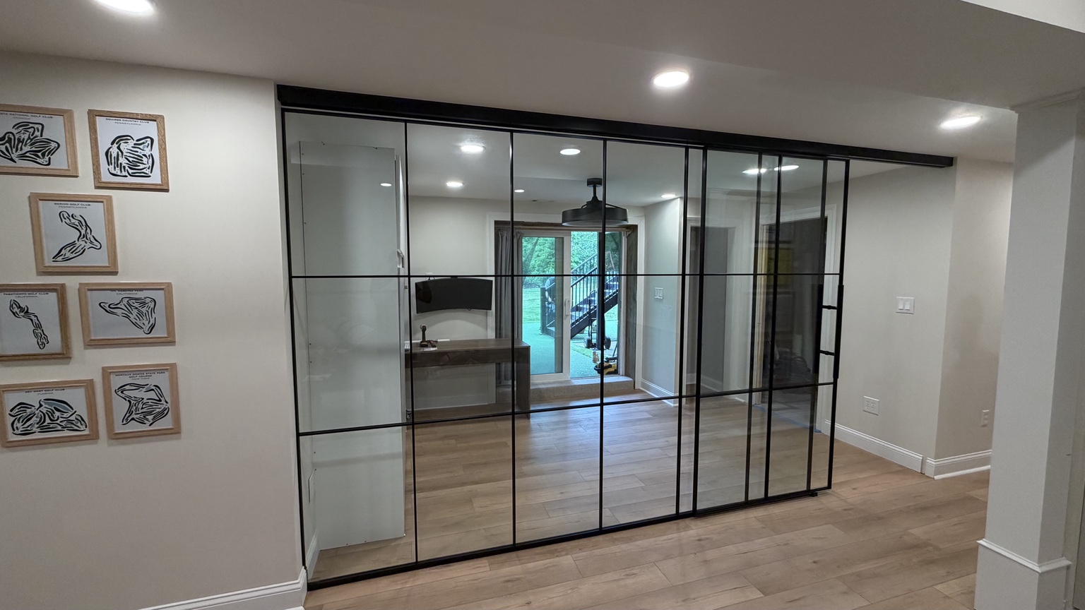 Wide black framed residential glass wall with sliding doors